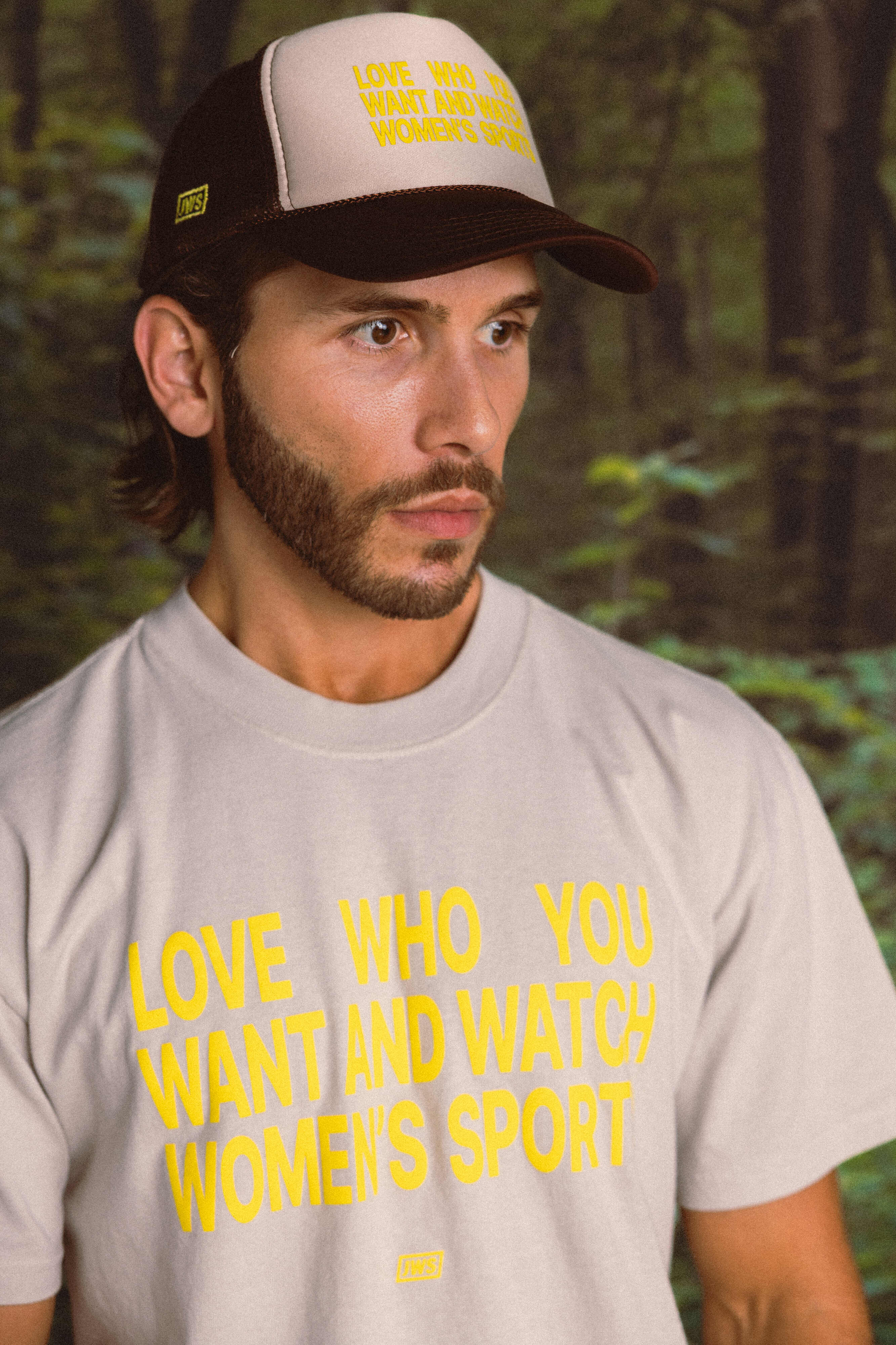 Person wearing a cap and t-shirt with motivational text in a forest setting