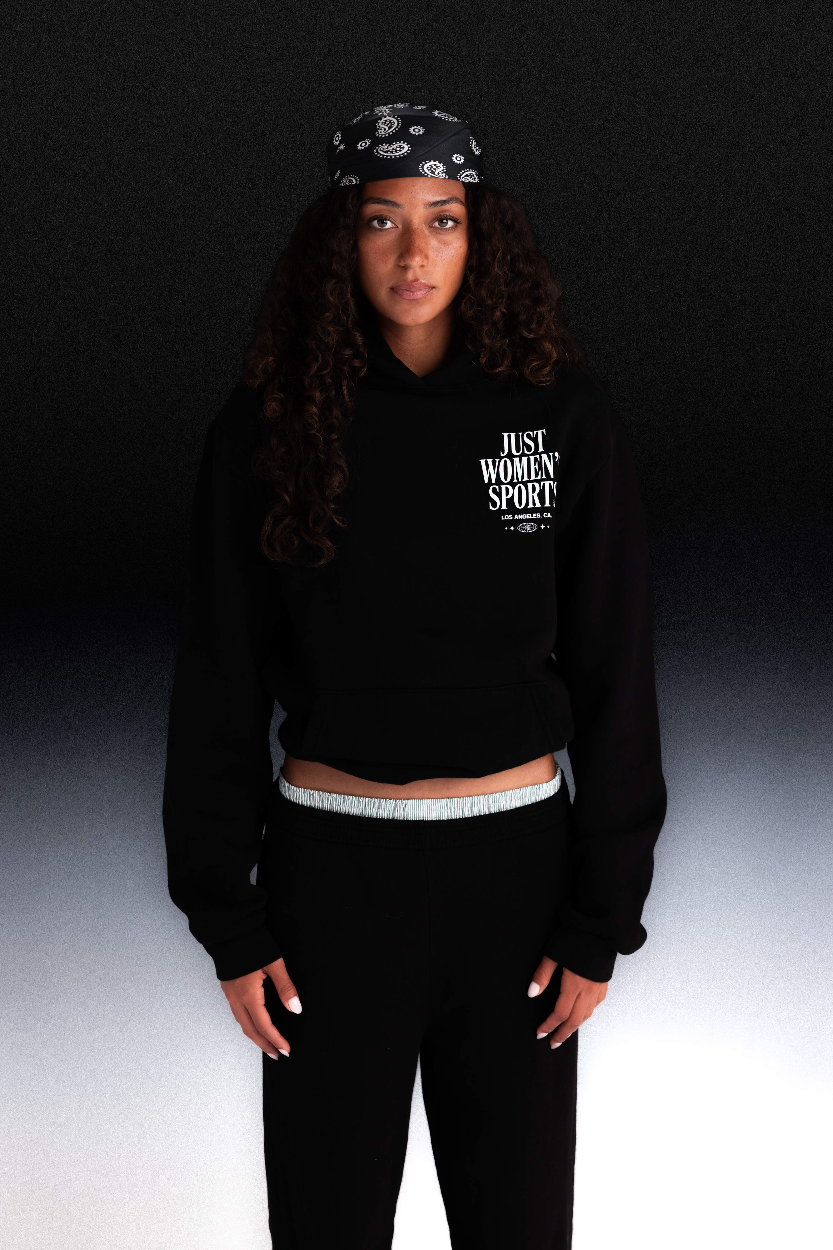 Person wearing a black hoodie with Just Women Sport text