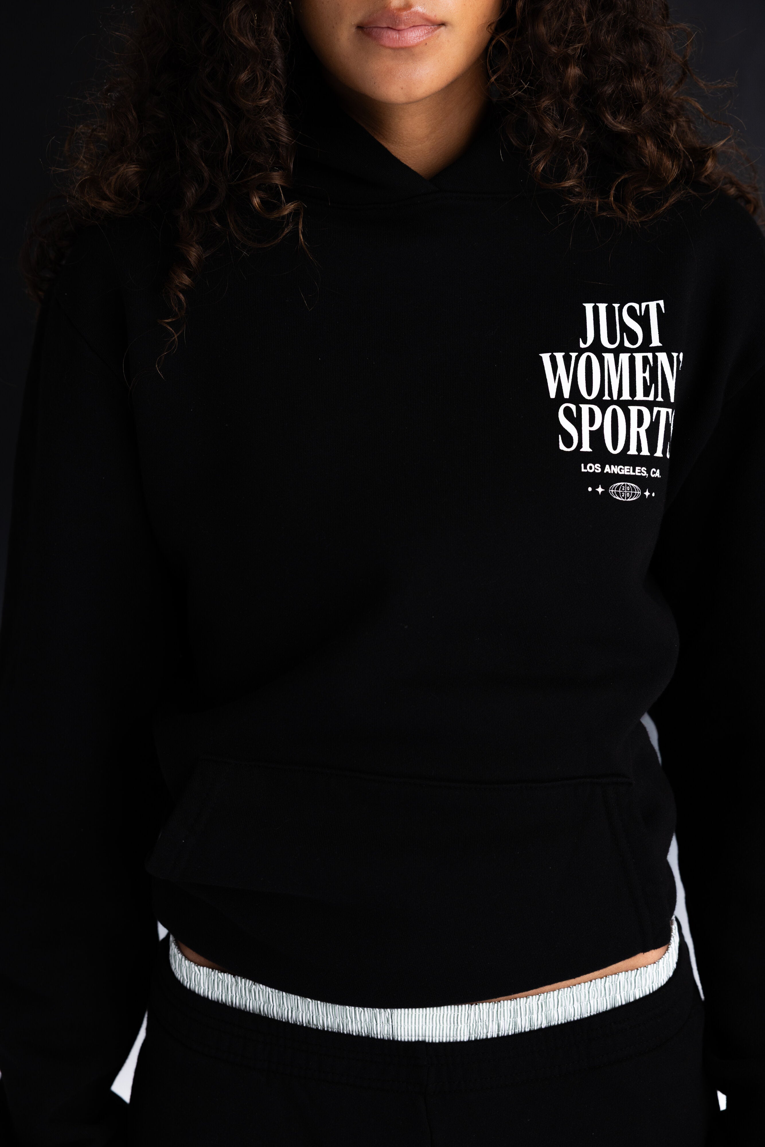 Person wearing a black hoodie with JUST WOMEN SPORT text