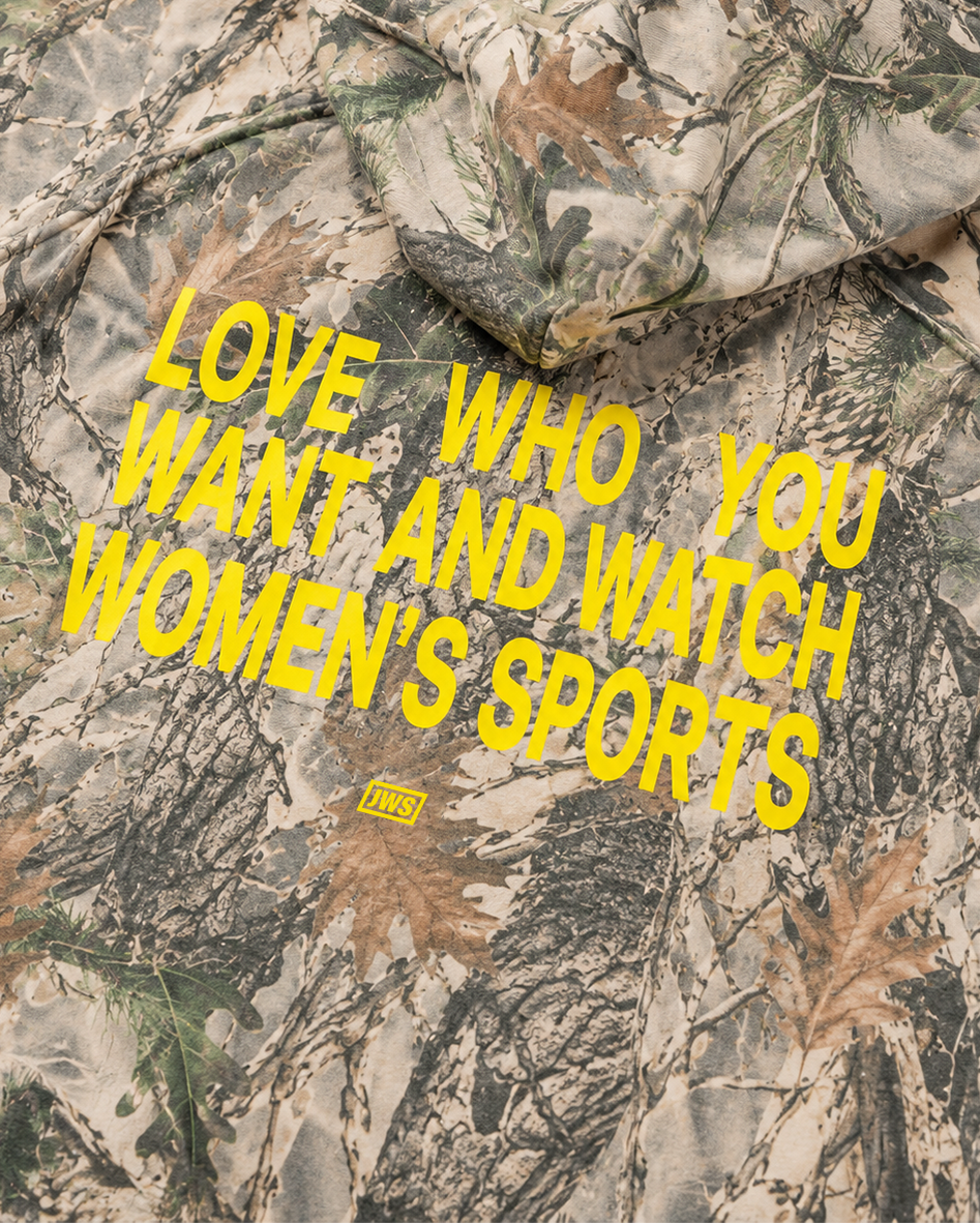 Camouflage jacket with yellow text Love who you want and watch women's sports