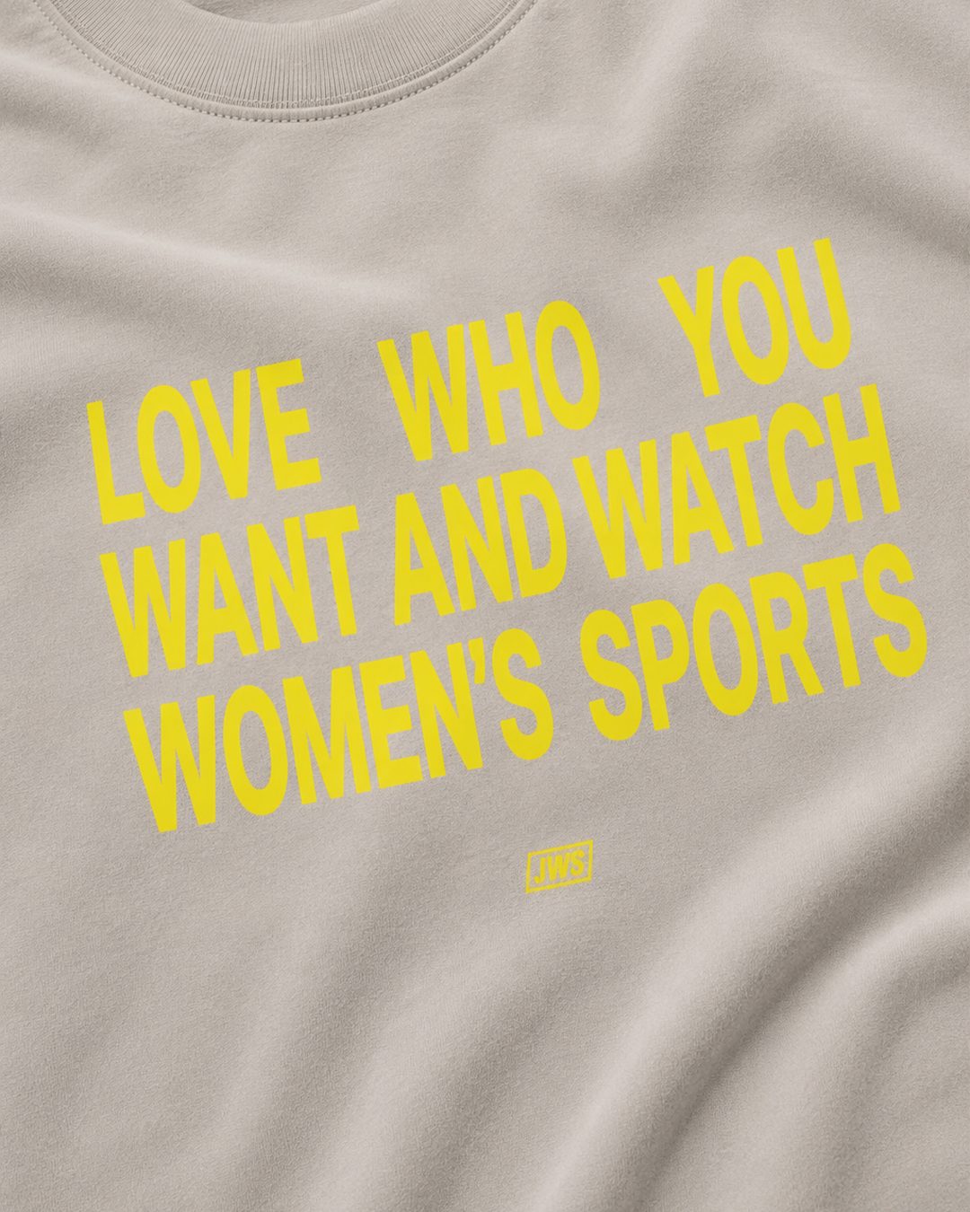 Beige shirt with yellow text Love who you want and watch women's sports