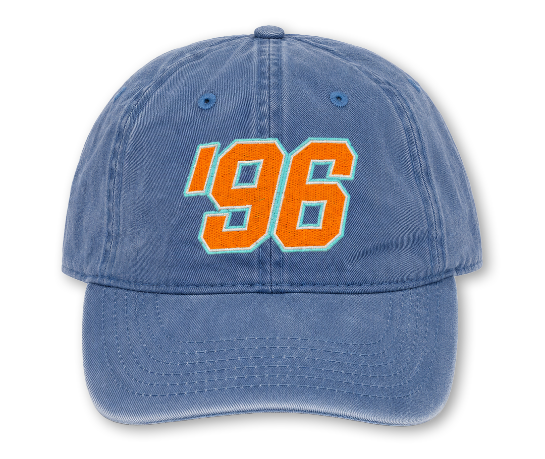 A washed blue baseball cap featuring the year '96 embroidered in orange with a light blue outline on the front.
